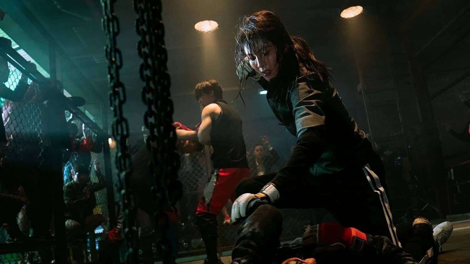 Yoon Ji-woo beats someone up in a fighting ring while several people fight in the background.